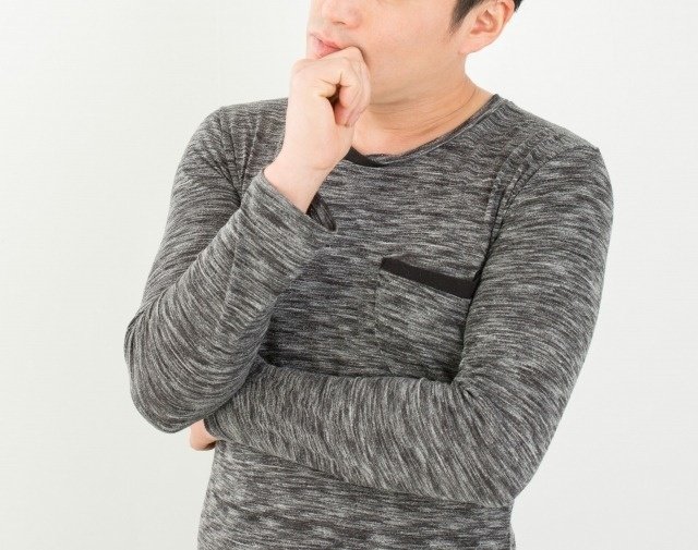 顎に手を添えて考える男性