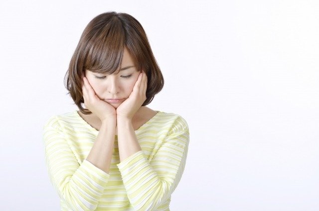 頬を押さえる女性