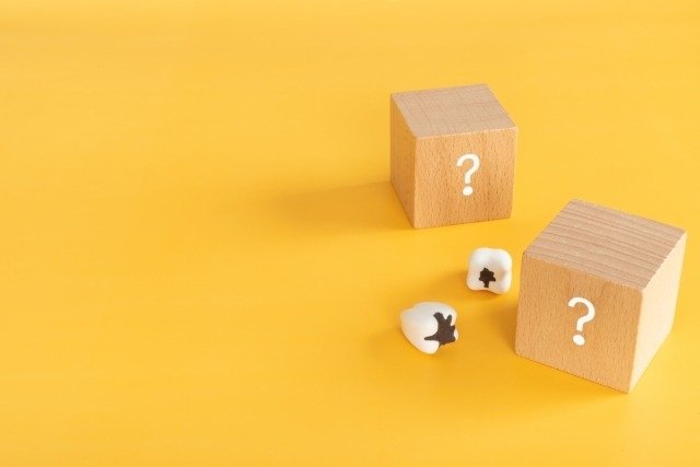 虫歯の模型とクエスチョンマークが書いてある積み木