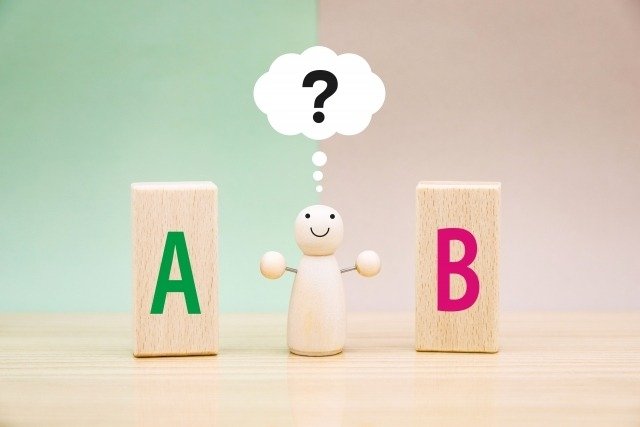 AとBを比べて疑問符を浮かべる人形