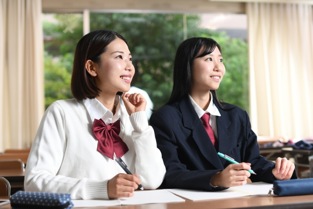 教室の隣同士の席で勉強している女子中学生
