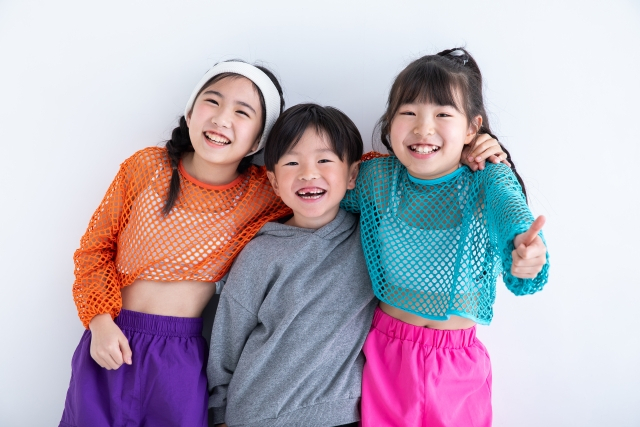 笑顔で肩を組む3人の子ども